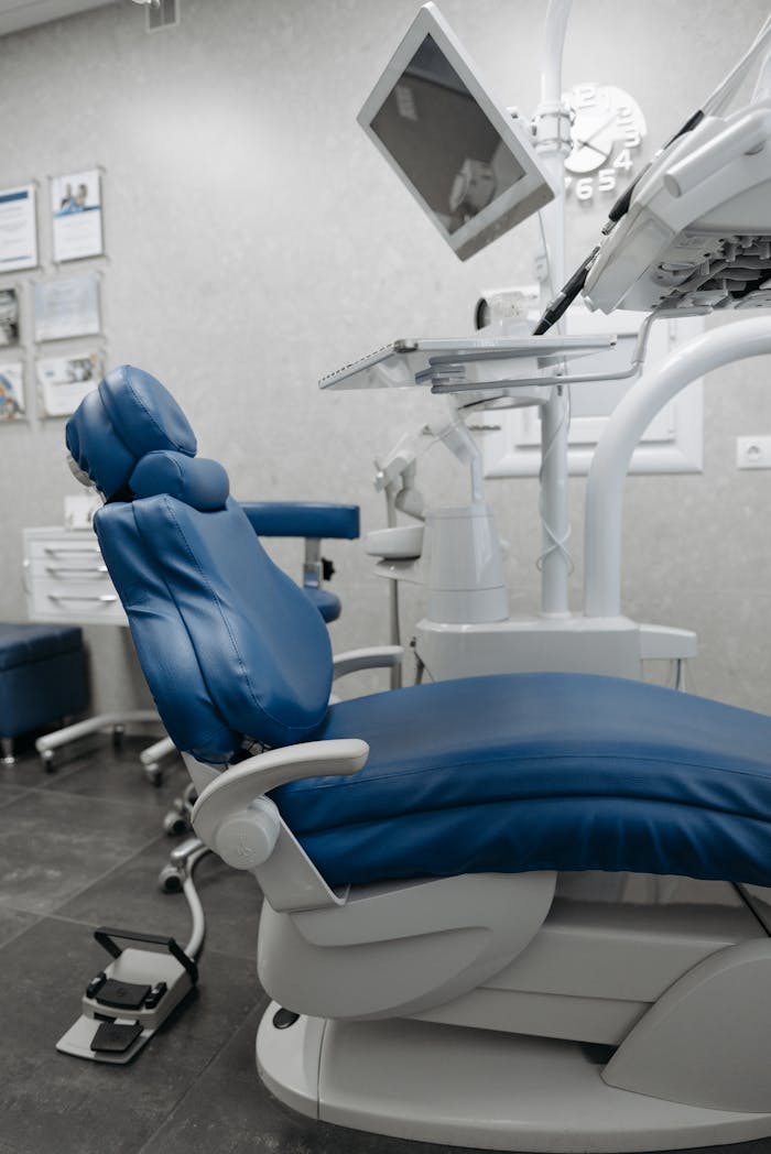 A clean dental office showcasing state-of-the-art equipment and a blue dental chair, ready for patients.